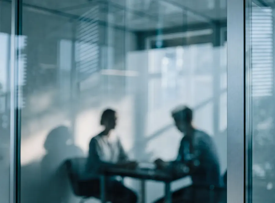 Twee mensen in een rustig gesprek achter een glazen wand